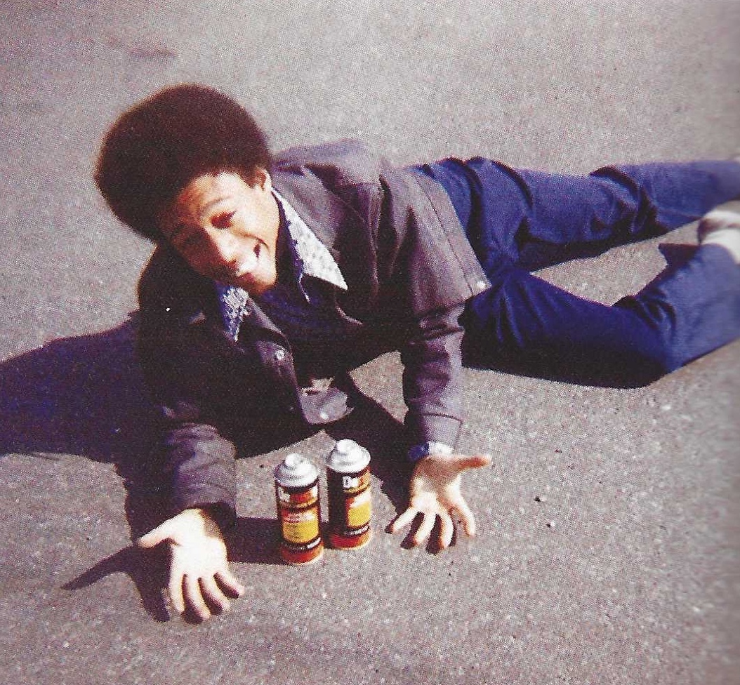 Blade lying on the pavement joking with two spray cans