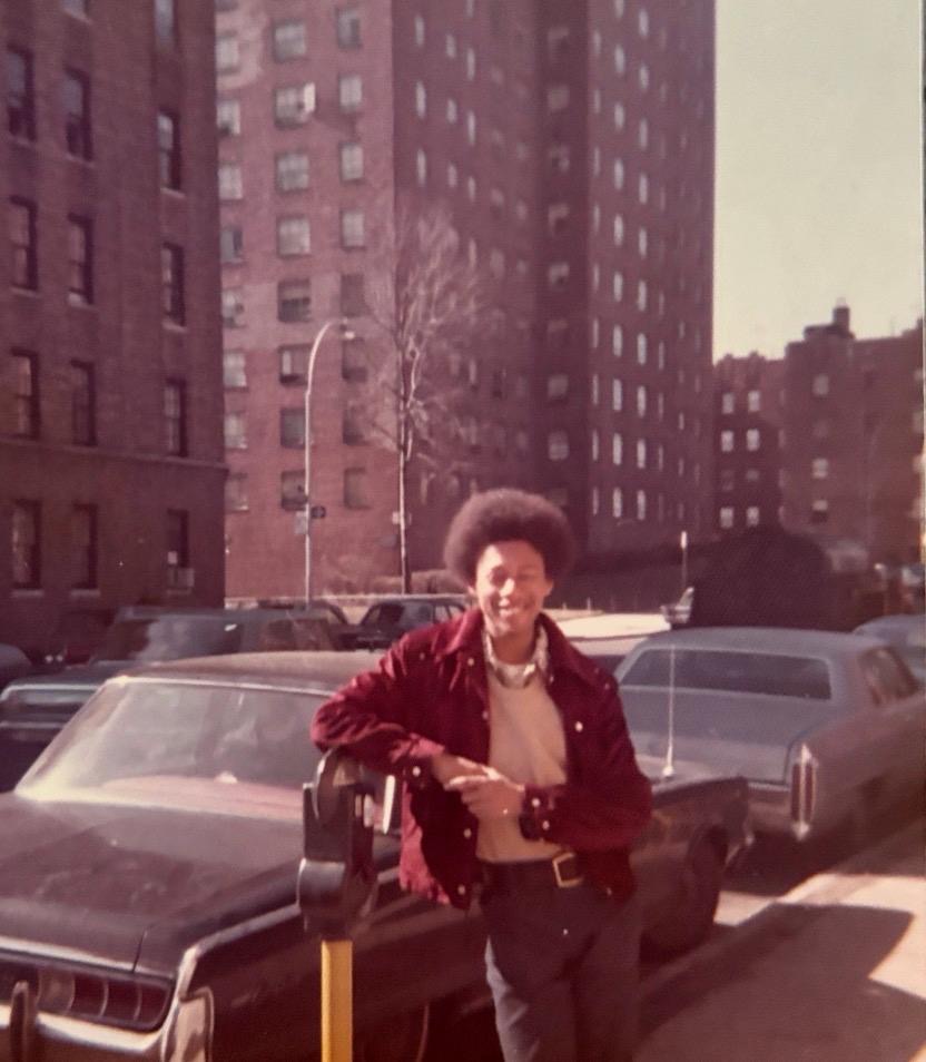 Blade leaning on a parking meter in front of New York housing blocks
