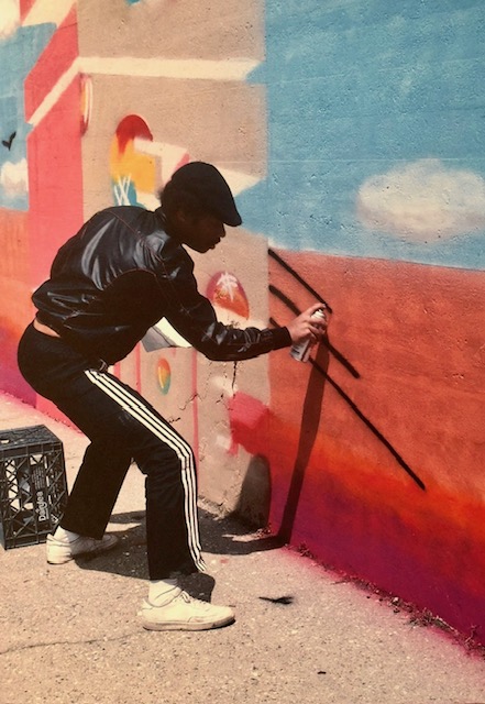 Blade spray-painting an outdoor wall mural in New York